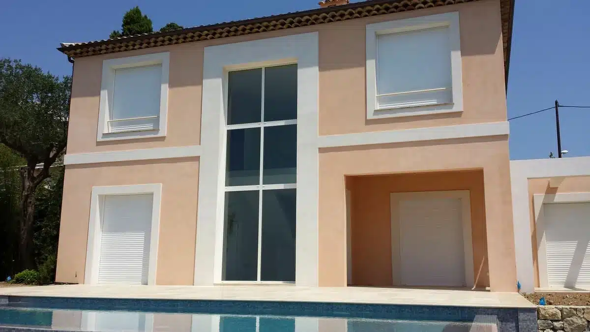 Volets roulants motorisés intégrés dans coffres tunnel invisibles en façade, installation à Villefranche-sur-Mer.