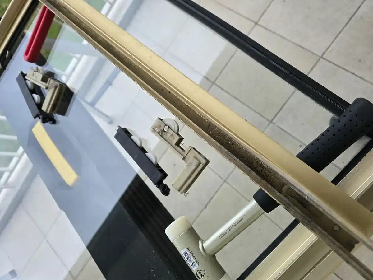 Intervention à Cagnes-sur-Mer pour le remplacement des roulettes d’une baie vitrée en aluminium, assurant une réparation durable et un coulissement fluide.