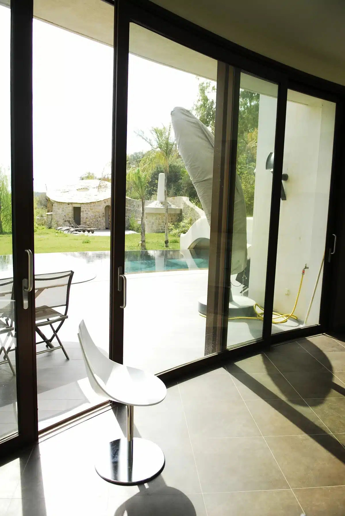 Baie vitrée coulissante XXL bombée en aluminium Technal, finition couleur rouille, installée à Peille. Un coulissant arrondi haut de gamme offrant une ouverture panoramique et une luminosité exceptionnelle sur l’extérieur.