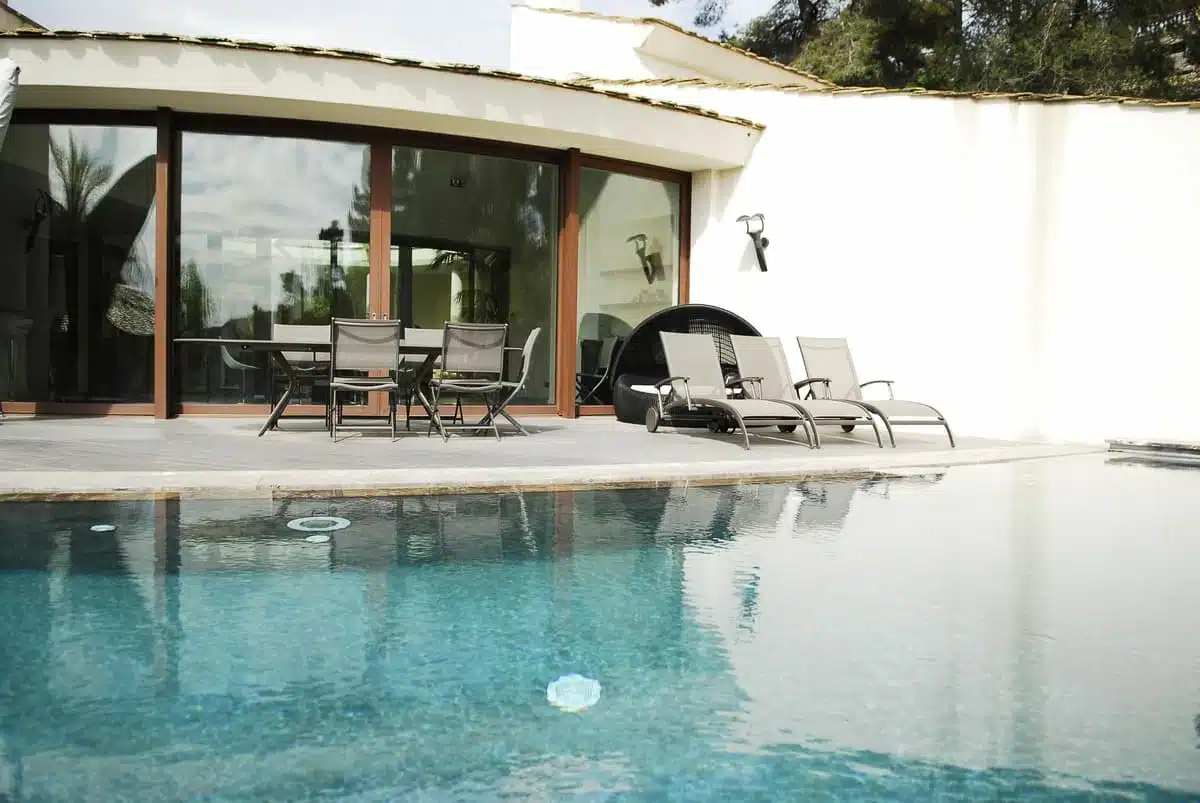 Baie vitrée coulissante bombée en aluminium Technal installée à Peille, offrant une ouverture panoramique sur la terrasse et la piscine. Une réalisation élégante et sur mesure alliant design moderne et luminosité exceptionnelle.