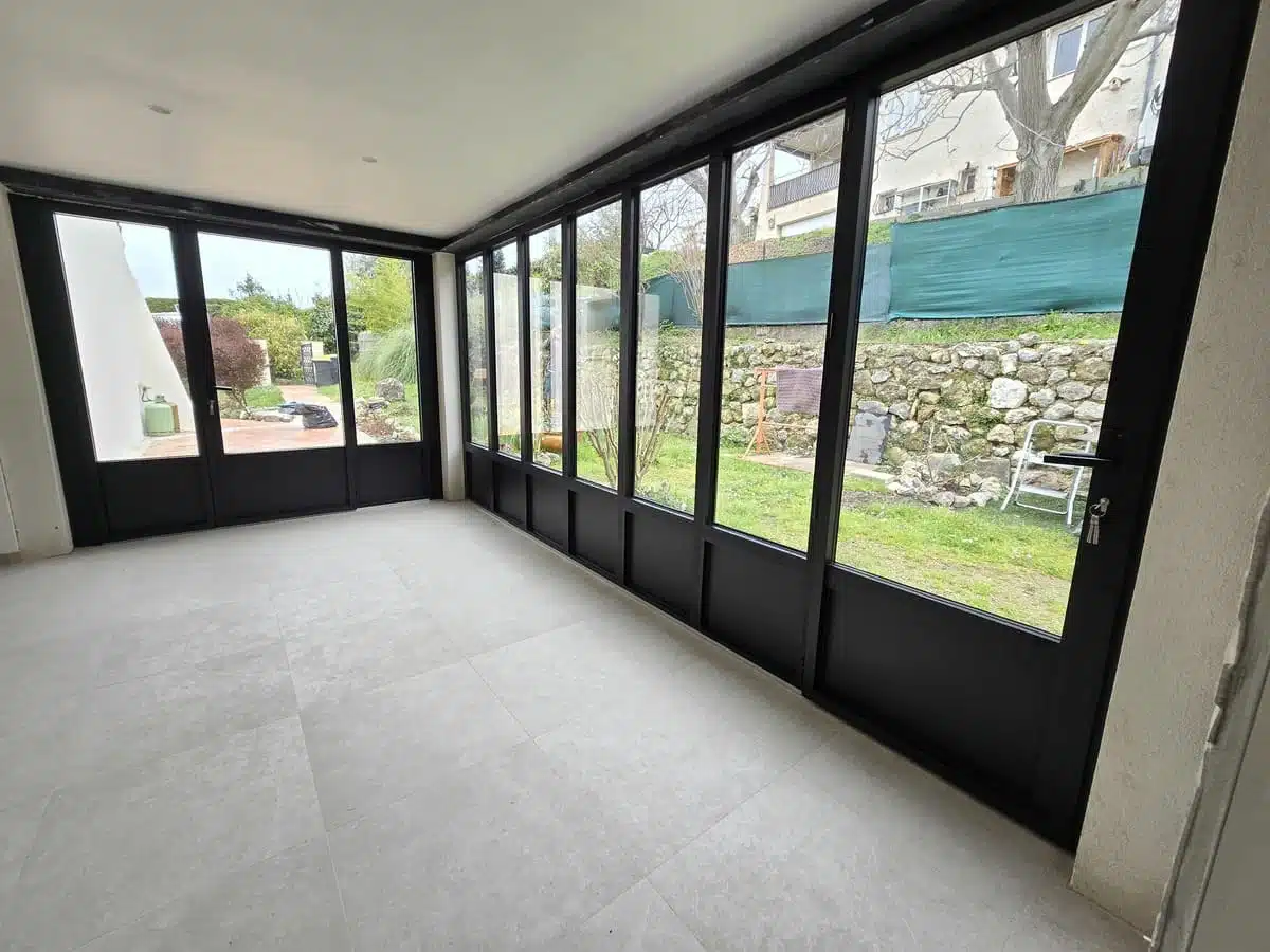 Fermeture de loggia et entrée réalisée en menuiseries aluminium noir K-Line à Tourrettes-sur-Loup. Une installation élégante et moderne offrant luminosité, isolation et sécurité tout en préservant le style contemporain de la maison.