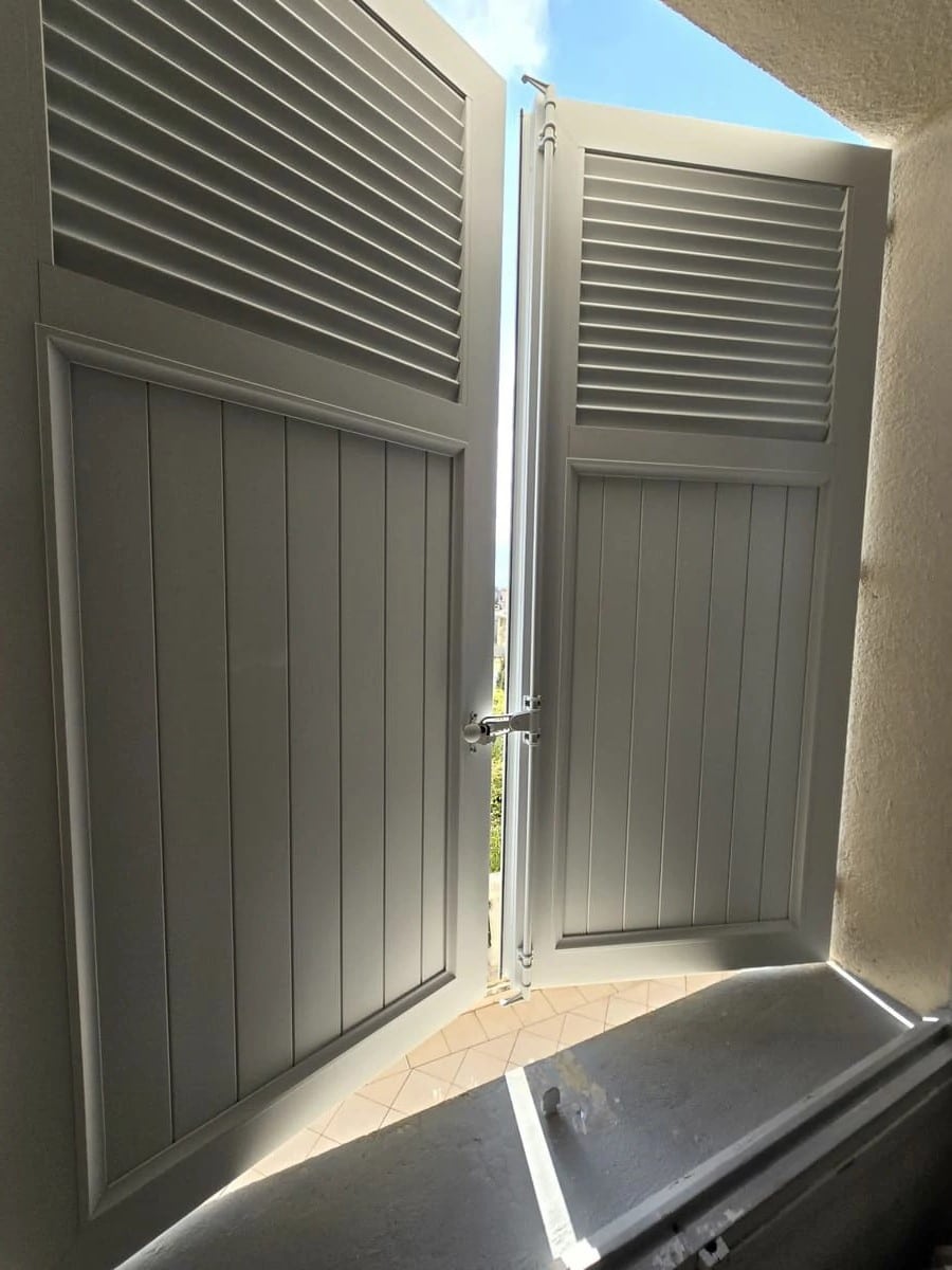 Volet battant aluminium EHRET RAL 7035 avec persienne lames américaines et partie panneaux installé à Cannes.