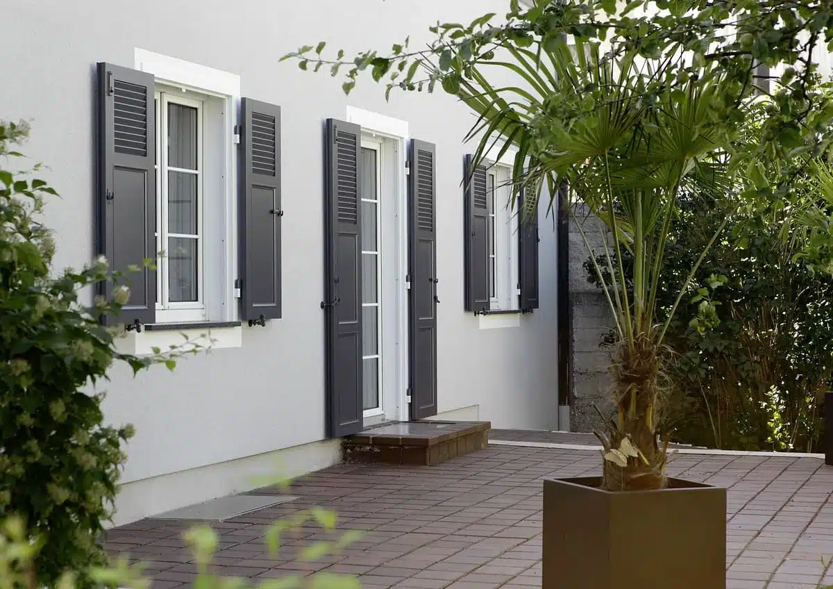 Volets battants aluminium gris anthracite avec persiennes et panneaux pleins installés dans les Alpes-Maritimes.